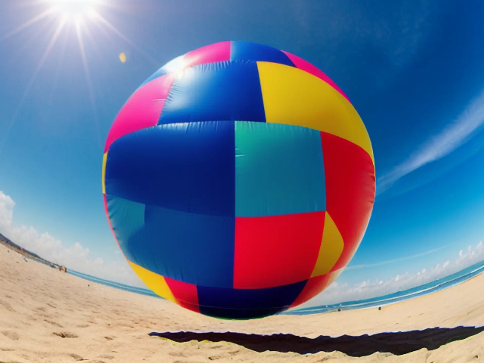 Kleurrijke mega strandbal tegen stralend blauwe zomerlucht op strand