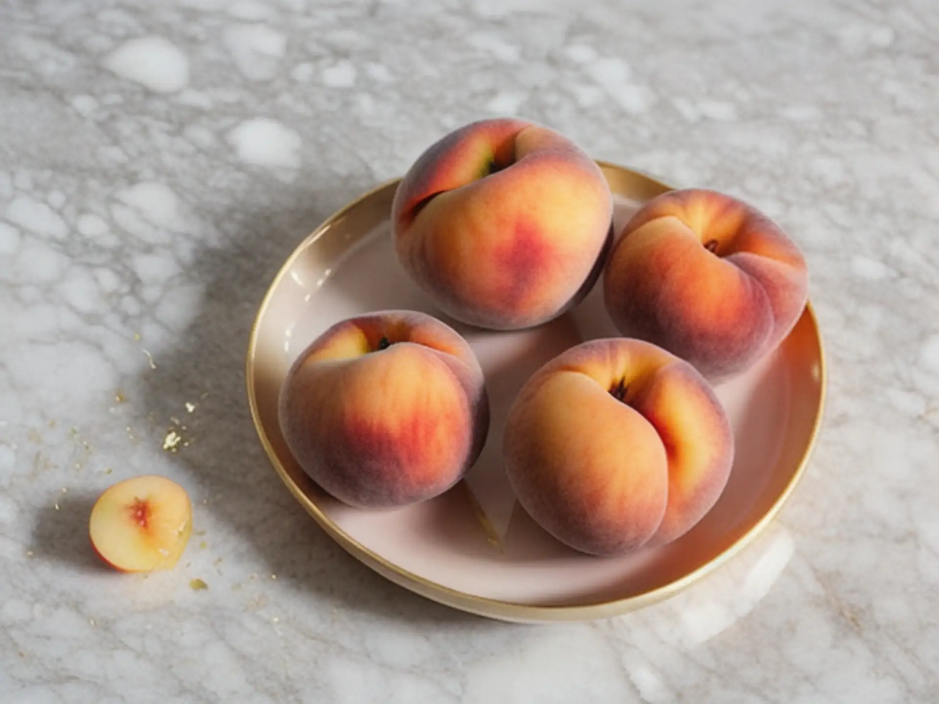Verse perziken op roze bord tegen marmeren aanrecht - food fotografie