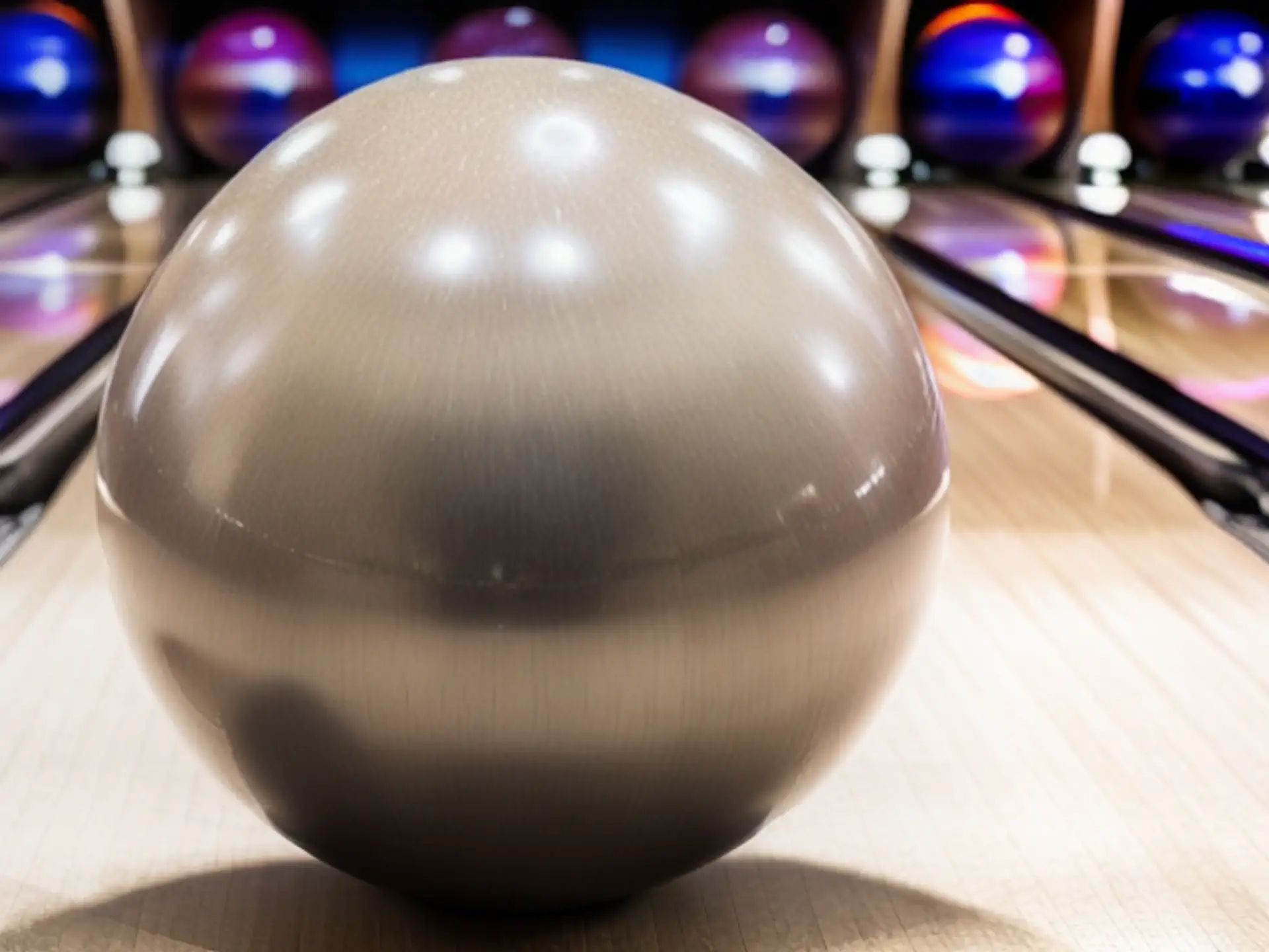 Close-up bowlingbal op houten bowlingbaan met kleurrijke pins