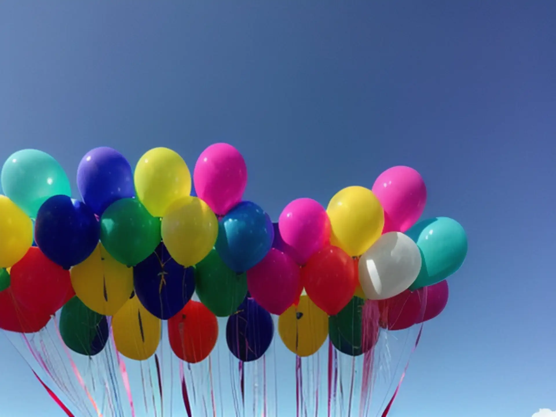 Kleurrijke feestballonnen tegen strakblauwe zomerlucht
