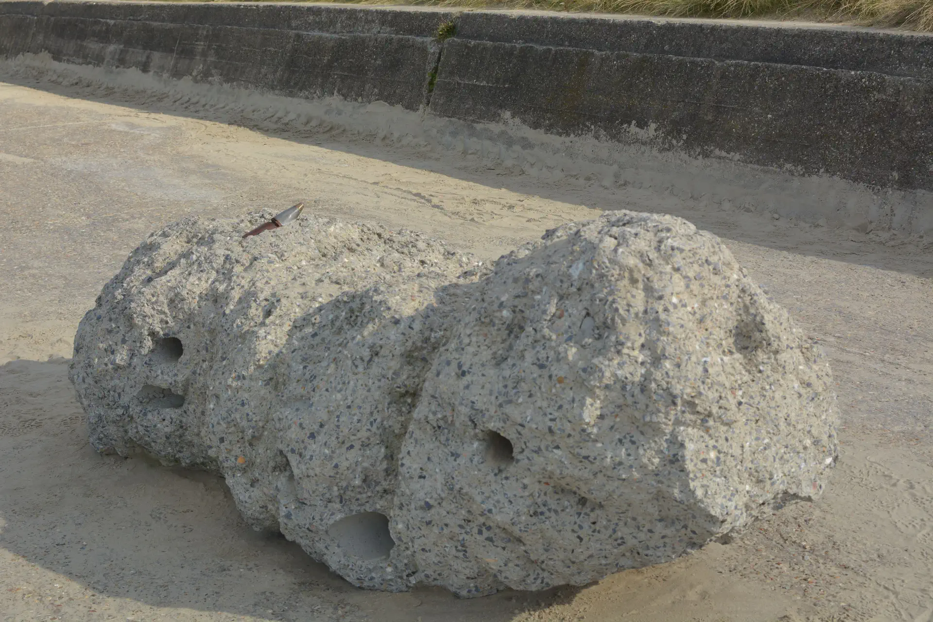 Rotsblok met kogel in op de dijk van De Panne