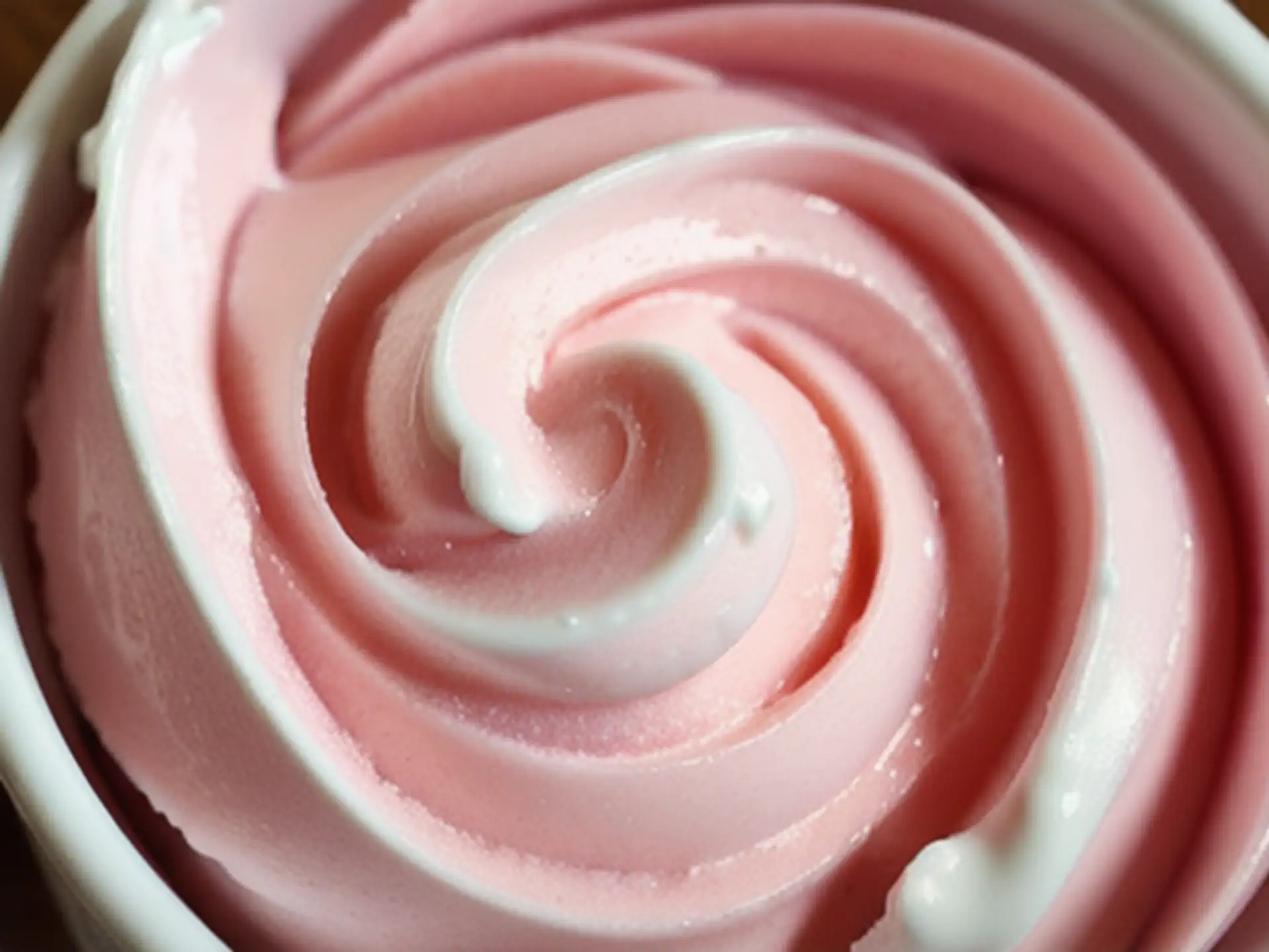 Romige roze slagroom swirl in close-up voor cupcake decoratie