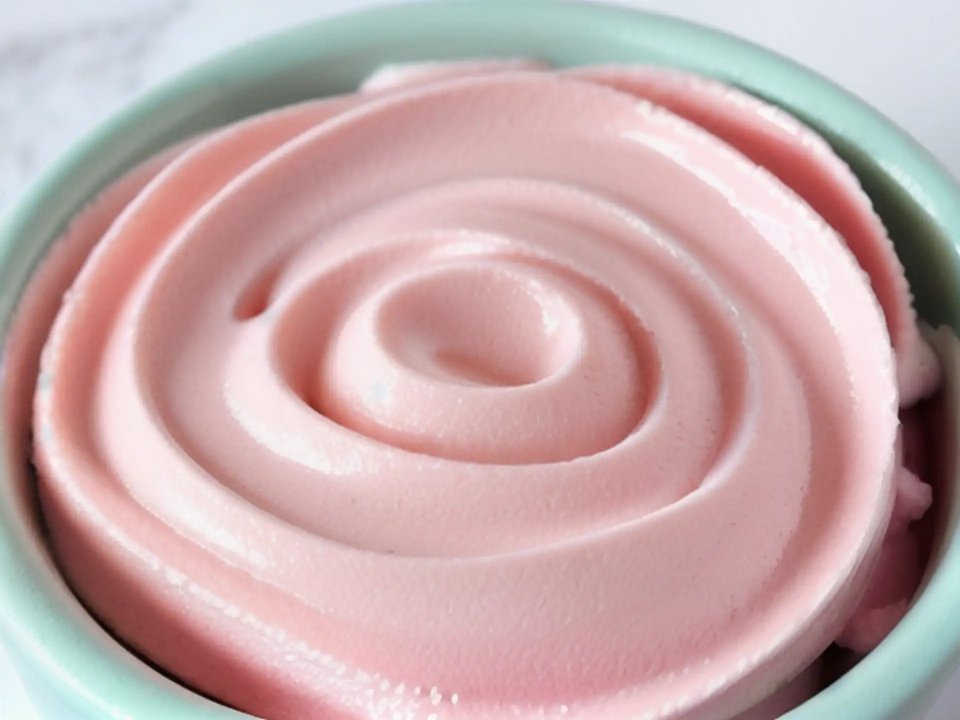 Roze romige mousse dessert in mintgroene kom close-up fotografie